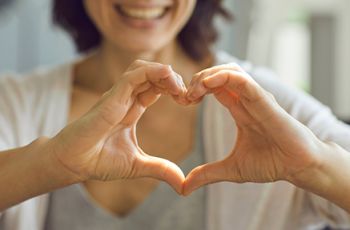 Staying Heart Healthy - Image of a Woman with Heart shape sign